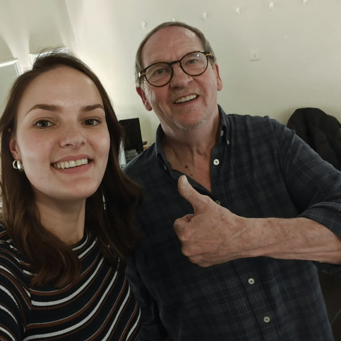 Een vrouw en een man poseren samen; de man steekt zijn duim op.